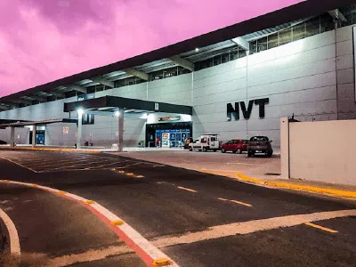 Entrada principal do Aeroporto Internacional de Navegantes - Ministro Victor Konder sob um céu crepuscular